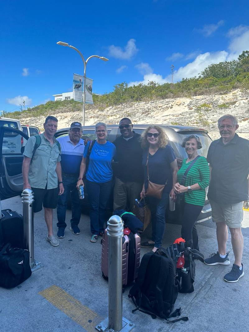 Secure Taxi driver welcoming a group of guests with their luggage